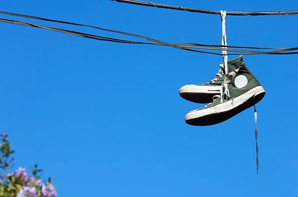 why do people hang shoes on power line